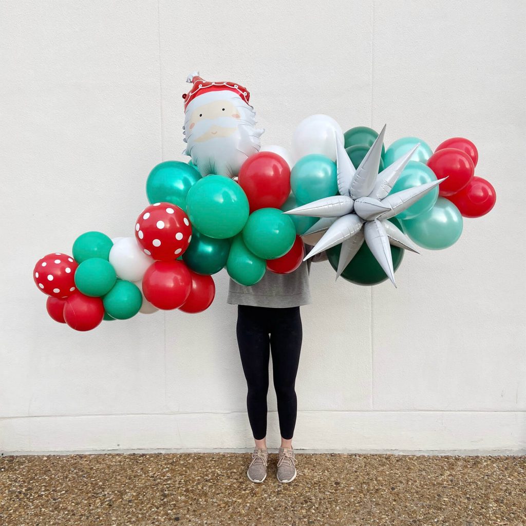 Cheery Christmas balloon garland for holiday parties with red, green, and white balloons from Just Peachy.